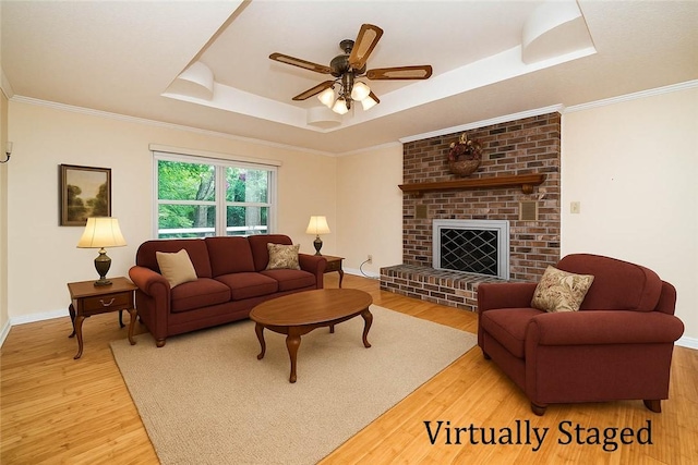 585 County Road 217, Berryville, AR 72616 - living room featuring a raised ceiling, light wood-type flooring, ceiling fan, baseboards, and ornamental molding