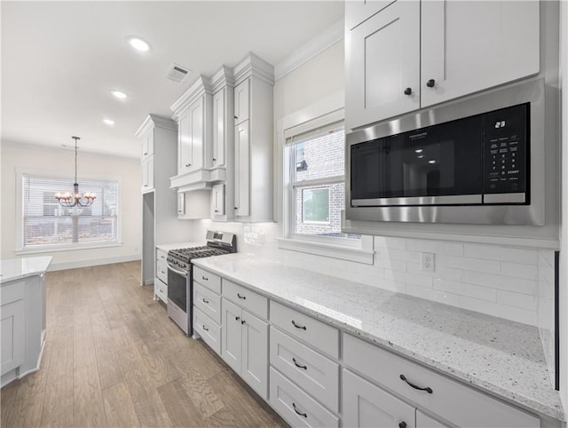 1821 Bluestem Dr, Centerton, AR 72719 - kitchen with appliances with stainless steel finishes, a chandelier, tasteful backsplash, healthy amount of natural light, and recessed lighting