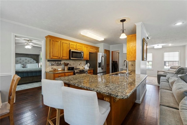 4 Hillcrest Dr, Holiday Island, AR 72631 - kitchen featuring stainless steel appliances, a sink, open floor plan, brown cabinets, and dark wood-style floors