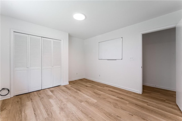 800 Summit Dr, Rogers, AR 72756 - unfurnished bedroom with light wood-style flooring, a closet, and baseboards