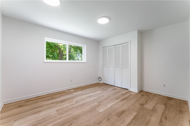 800 Summit Dr, Rogers, AR 72756 - unfurnished bedroom featuring light wood finished floors, a closet, and baseboards