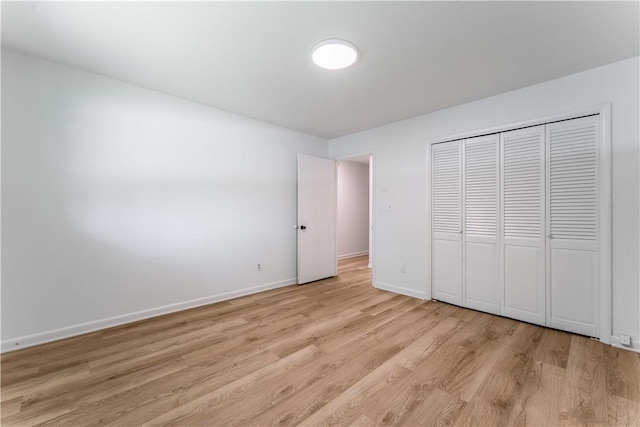 800 Summit Dr, Rogers, AR 72756 - unfurnished bedroom featuring light wood finished floors, baseboards, and a closet