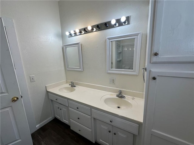 301 W Bean St, Lincoln, AR 72744 - bathroom featuring double vanity, wood finished floors, and a textured wall