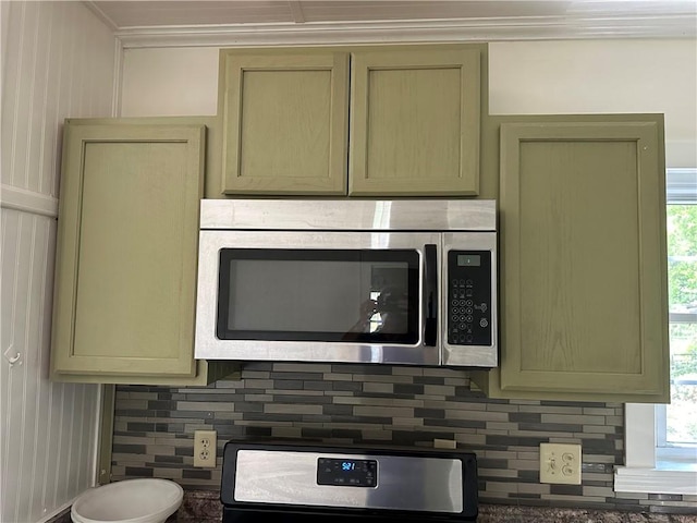 301 W Bean St, Lincoln, AR 72744 - kitchen view of stainless steel microwave, ornamental molding, backsplash, and stove