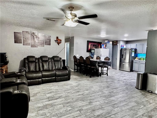 1297 Homestead Loop, Springdale, AR 72764 - living room with a textured ceiling, ceiling fan, and light wood finished floors