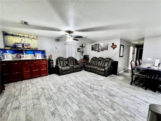 1297 Homestead Loop, Springdale, AR 72764 - living area featuring light wood finished floors, a ceiling fan, and a textured ceiling