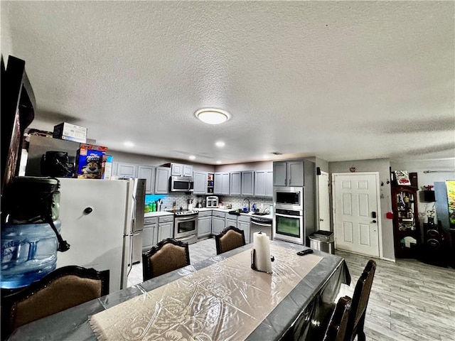 1297 Homestead Loop, Springdale, AR 72764 - dining room with a textured ceiling, light wood-type flooring, and recessed lighting