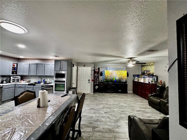 1297 Homestead Loop, Springdale, AR 72764 - living area with a textured ceiling, ceiling fan, and light wood-type flooring