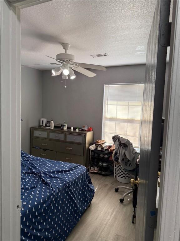 1269 E Homestead Loop, Springdale, AR 72764 - bedroom featuring a textured ceiling, wood finished floors, and ceiling fan