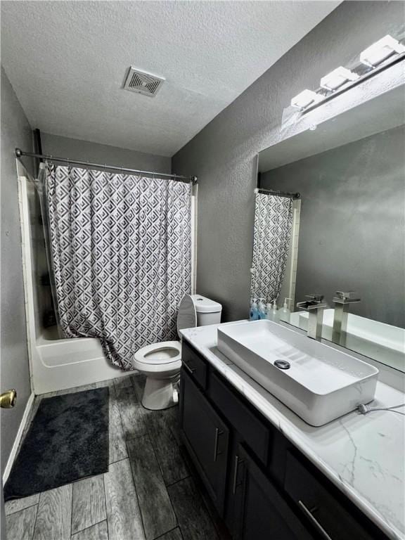 1269 E Homestead Loop, Springdale, AR 72764 - bathroom with vanity, a textured ceiling, wood finished floors, and shower / bath combination with curtain