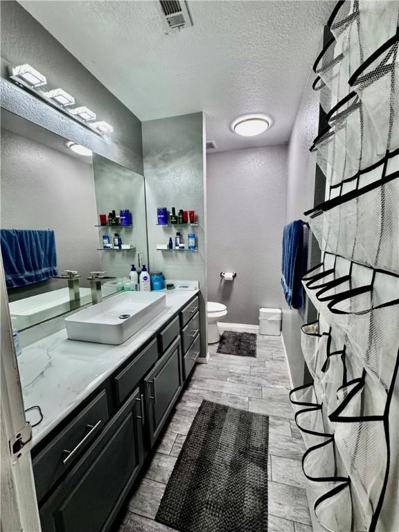 1269 E Homestead Loop, Springdale, AR 72764 - full bath featuring a textured ceiling, vanity, and wood finished floors