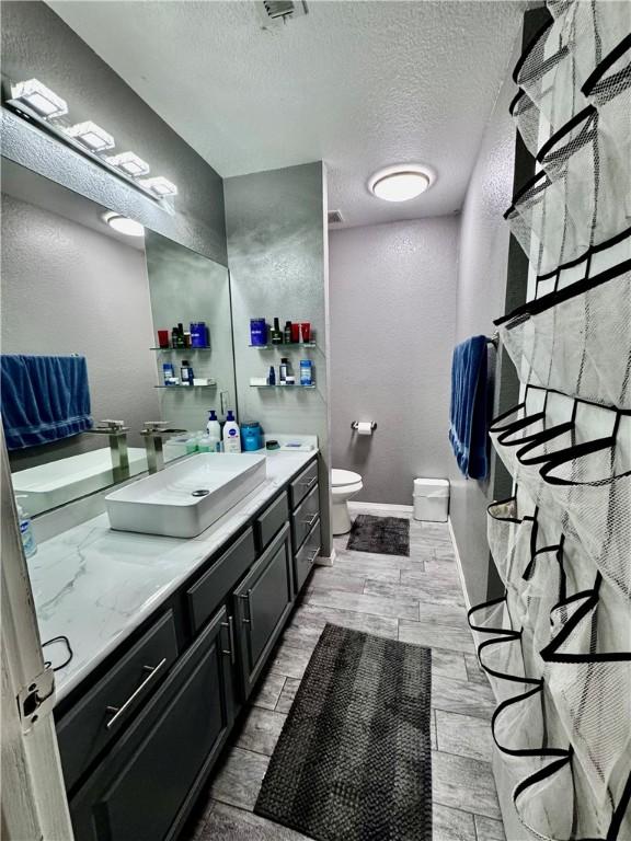 1269 E Homestead Loop, Springdale, AR 72764 - full bathroom featuring a textured ceiling, vanity, and wood finished floors