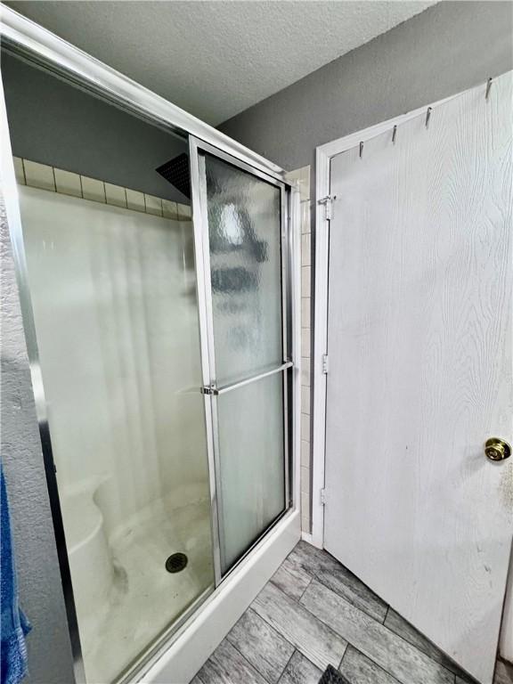 1269 E Homestead Loop, Springdale, AR 72764 - bathroom featuring a stall shower and a textured ceiling