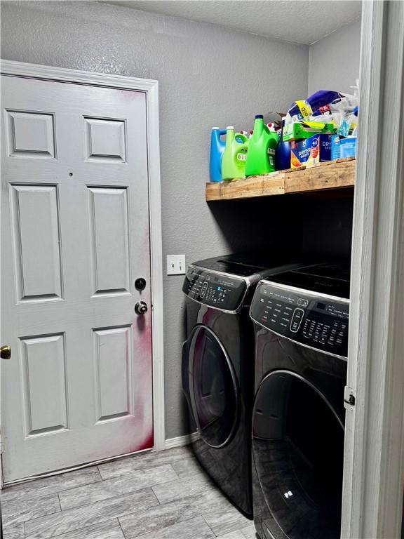 1269 E Homestead Loop, Springdale, AR 72764 - laundry area with washer and clothes dryer, wood tiled floors, and a textured wall