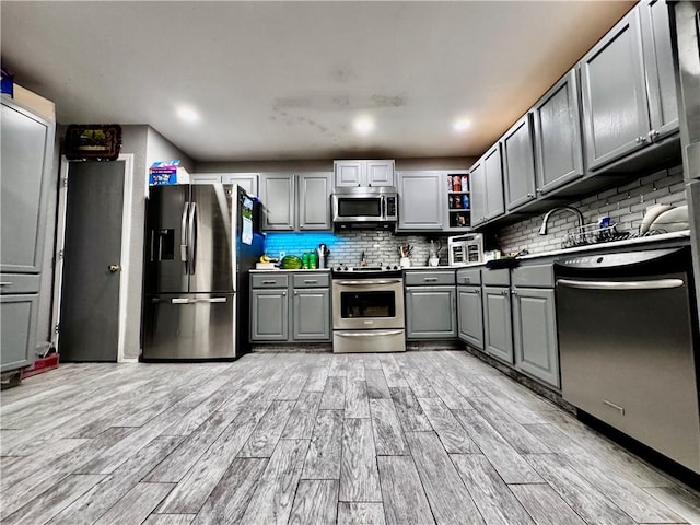1269 E Homestead Loop, Springdale, AR 72764 - kitchen with stainless steel appliances, gray cabinetry, light wood-style flooring, decorative backsplash, and recessed lighting