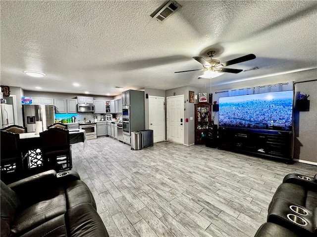 1269 E Homestead Loop, Springdale, AR 72764 - living area with ceiling fan, light wood-style floors, and a textured ceiling