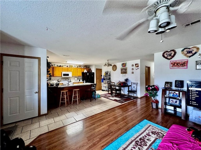 1269 E Homestead Loop, Springdale, AR 72764 - living room with a textured ceiling, light wood-style floors, and ceiling fan