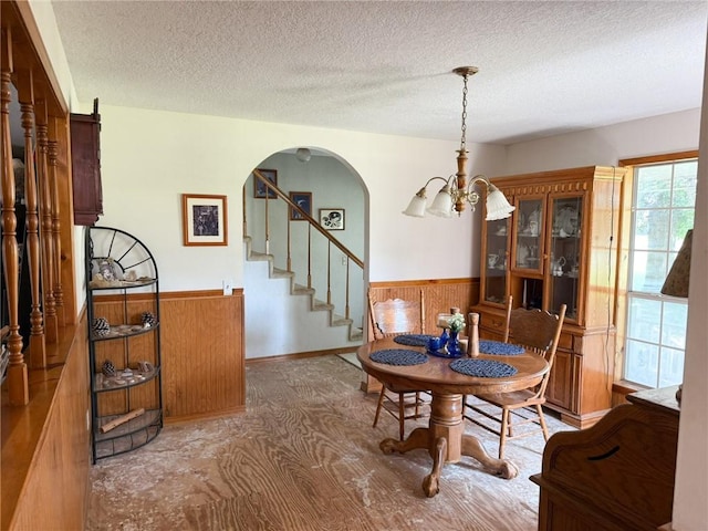 291 S Industrial Park Rd, Prairie Grove, AR 72753 - dining room featuring wainscoting, stairway, wooden walls, a chandelier, and a textured ceiling