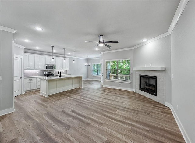 9 Sheidaig Ln, Bella Vista, AR 72715 - living area with ceiling fan, ornamental molding, recessed lighting, light wood-type flooring, and a brick fireplace