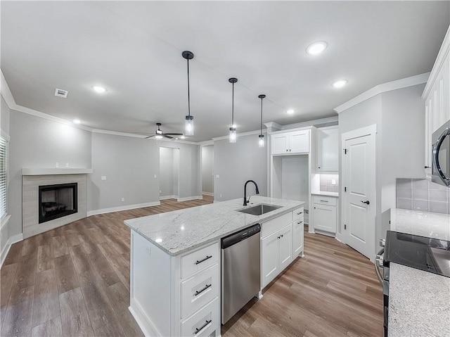 9 Sheidaig Ln, Bella Vista, AR 72715 - kitchen featuring stainless steel appliances, crown molding, a ceiling fan, light wood finished floors, and white cabinets