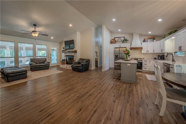 6 Muker Ln, Bella Vista, AR 72714 - kitchen with custom range hood, open floor plan, appliances with stainless steel finishes, lofted ceiling, and a kitchen island