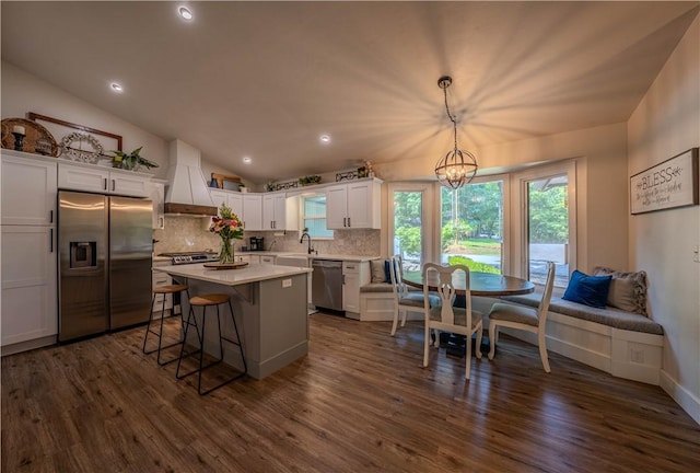 6 Muker Ln, Bella Vista, AR 72714 - kitchen with stainless steel appliances, custom range hood, a sink, tasteful backsplash, and white cabinetry