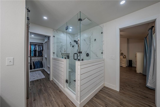 6 Muker Ln, Bella Vista, AR 72714 - full bathroom featuring wood finished floors, a marble finish shower, a spacious closet, recessed lighting, and baseboards