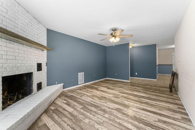 10 Magrath Ln, Bella Vista, AR 72715 - unfurnished living room with ceiling fan, wood finished floors, a fireplace, and baseboards