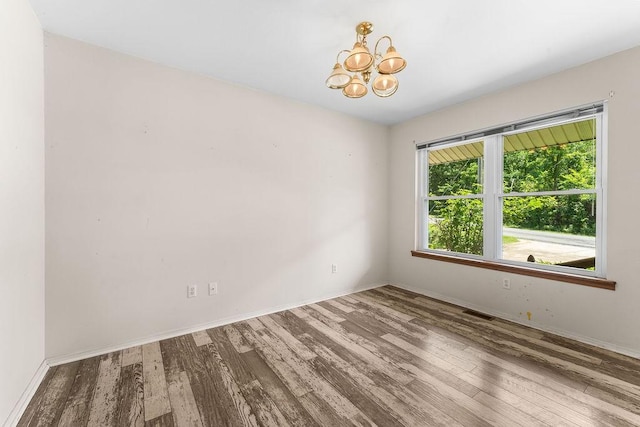 10 Magrath Ln, Bella Vista, AR 72715 - empty room featuring wood finished floors, a chandelier, and baseboards