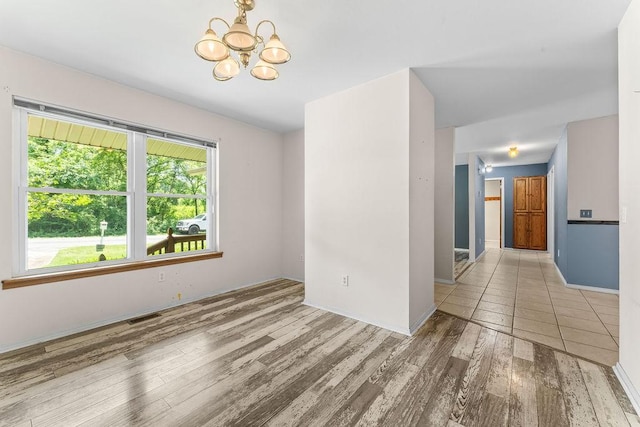 10 Magrath Ln, Bella Vista, AR 72715 - unfurnished room featuring a chandelier, wood finished floors, and baseboards