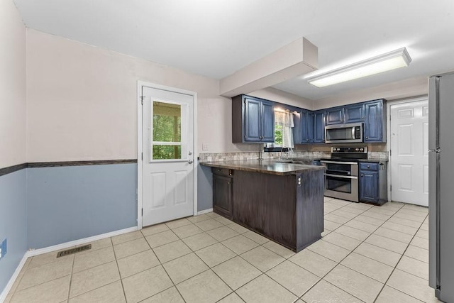 10 Magrath Ln, Bella Vista, AR 72715 - kitchen featuring stainless steel appliances, a peninsula, dark countertops, blue cabinetry, and light tile patterned flooring