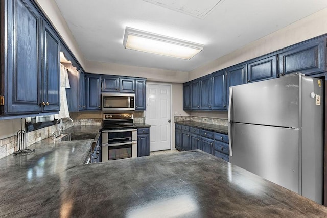 10 Magrath Ln, Bella Vista, AR 72715 - kitchen featuring appliances with stainless steel finishes, dark countertops, blue cabinets, a sink, and a peninsula