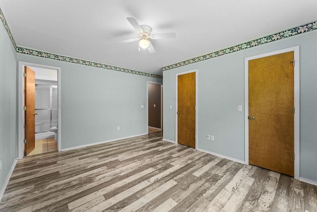 10 Magrath Ln, Bella Vista, AR 72715 - unfurnished bedroom featuring wood finished floors, baseboards, ensuite bathroom, and ceiling fan