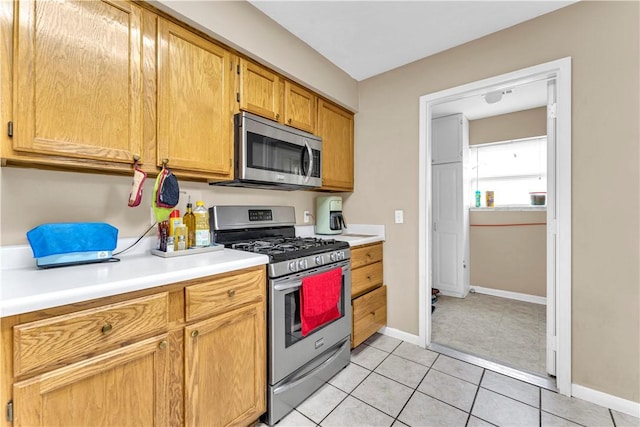 802 Buford St, Springdale, AR 72762 - kitchen featuring stainless steel appliances, light countertops, light tile patterned flooring, and baseboards