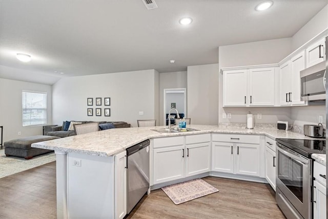 2213 E Fennec St, Siloam Springs, AR 72761 - kitchen featuring a sink, appliances with stainless steel finishes, a peninsula, white cabinetry, and open floor plan