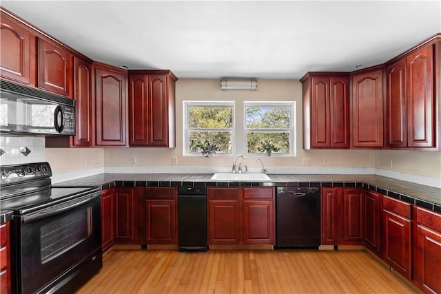 11021 Lathams Landing Rd, Garfield, AR 72732 - kitchen with black appliances, reddish brown cabinets, a sink, tile countertops, and light wood finished floors