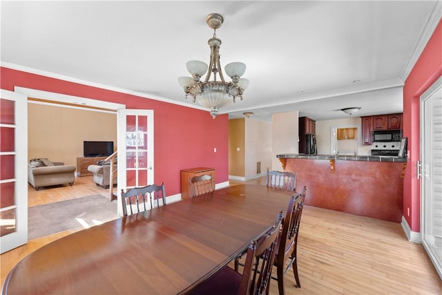 11021 Lathams Landing Rd, Garfield, AR 72732 - dining area with a chandelier, light wood finished floors, ornamental molding, and baseboards