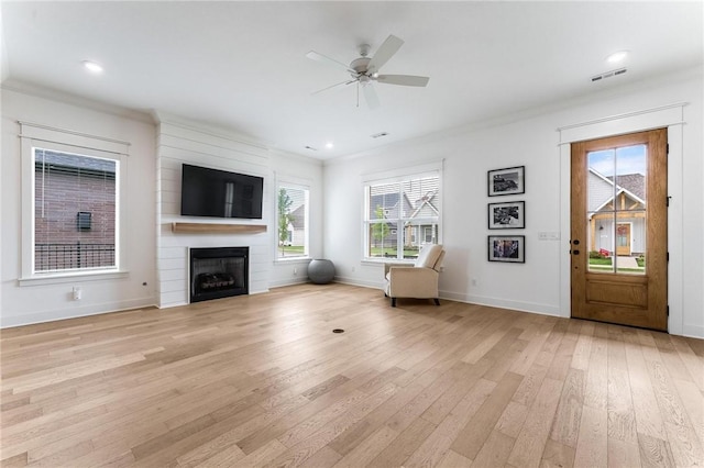 6741 Garden Trail Ave, Springdale, AR 72762 - living area featuring light wood-style flooring, healthy amount of natural light, a ceiling fan, a fireplace, and crown molding