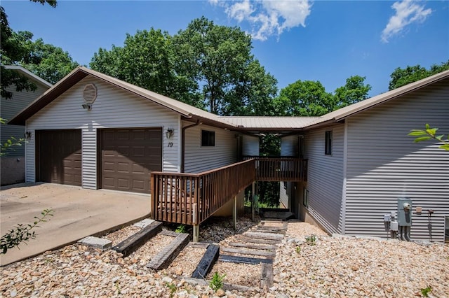 19 Bobwhite Ln, Holiday Island, AR 72631 - view of front facade with a garage, driveway, a metal roof, and a deck