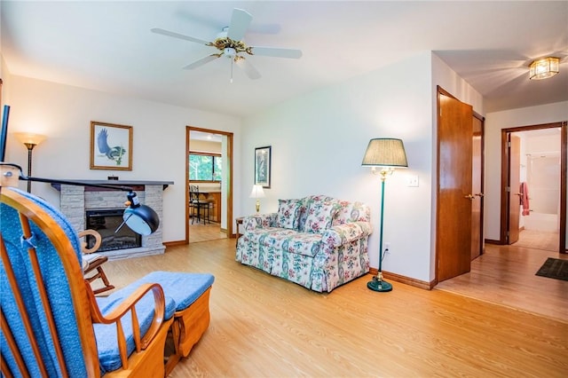 19 Bobwhite Ln, Holiday Island, AR 72631 - living room with light wood-style flooring, ceiling fan, and a fireplace