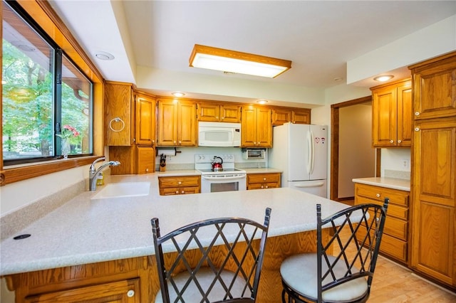 19 Bobwhite Ln, Holiday Island, AR 72631 - kitchen with white appliances, a peninsula, light countertops, a kitchen breakfast bar, and brown cabinets