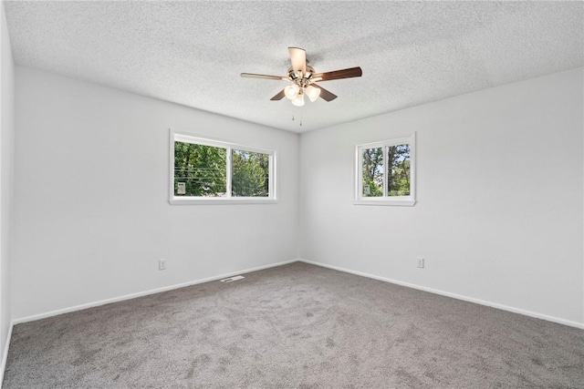 308 Kane St, Siloam Springs, AR 72761 - empty room featuring a ceiling fan, plenty of natural light, carpet floors, and a textured ceiling