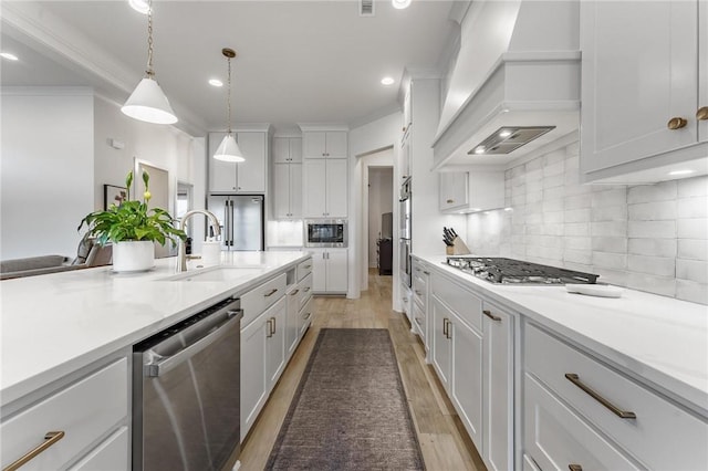 8003 W Claverton St, Rogers, AR 72758 - kitchen with stainless steel appliances, premium range hood, white cabinets, light countertops, and light wood-style floors