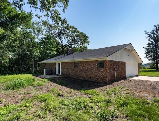50233 S 725th Rd, Colcord, OK 74338 - view of side of property featuring brick siding, a garage, driveway, a chimney, and a patio area