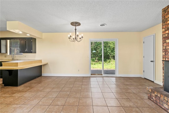 50233 S 725th Rd, Colcord, OK 74338 - kitchen with light countertops, a textured ceiling, a chandelier, a peninsula, and a breakfast bar area