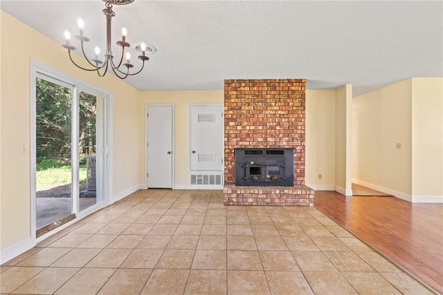 50233 S 725th Rd, Colcord, OK 74338 - unfurnished living room featuring a chandelier, a textured ceiling, and light wood-type flooring
