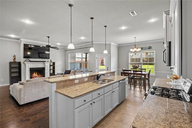 1511 Aniston Rd, Centerton, AR 72719 - kitchen with appliances with stainless steel finishes, a warm lit fireplace, ornamental molding, a ceiling fan, and hanging light fixtures