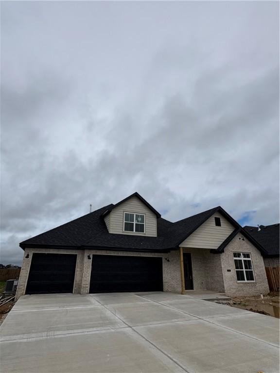 1309 Carrara, Tontitown, AR 72762 - view of front of home featuring driveway, an attached garage, and a shingled roof