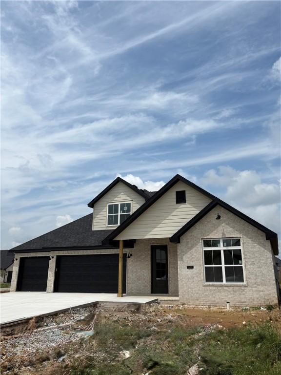 1309 Carrara, Tontitown, AR 72762 - view of front facade featuring driveway, an attached garage, and roof with shingles