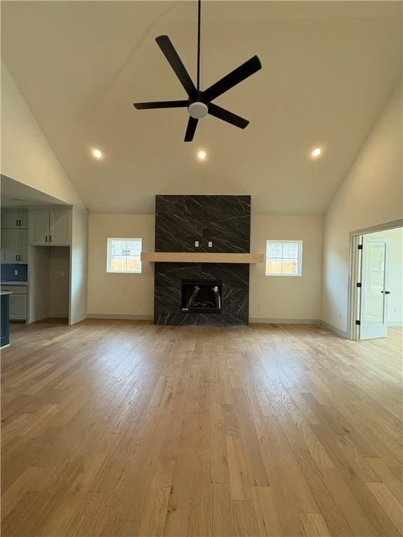 1309 Carrara, Tontitown, AR 72762 - unfurnished living room featuring high vaulted ceiling, ceiling fan, light wood-style flooring, a high end fireplace, and recessed lighting